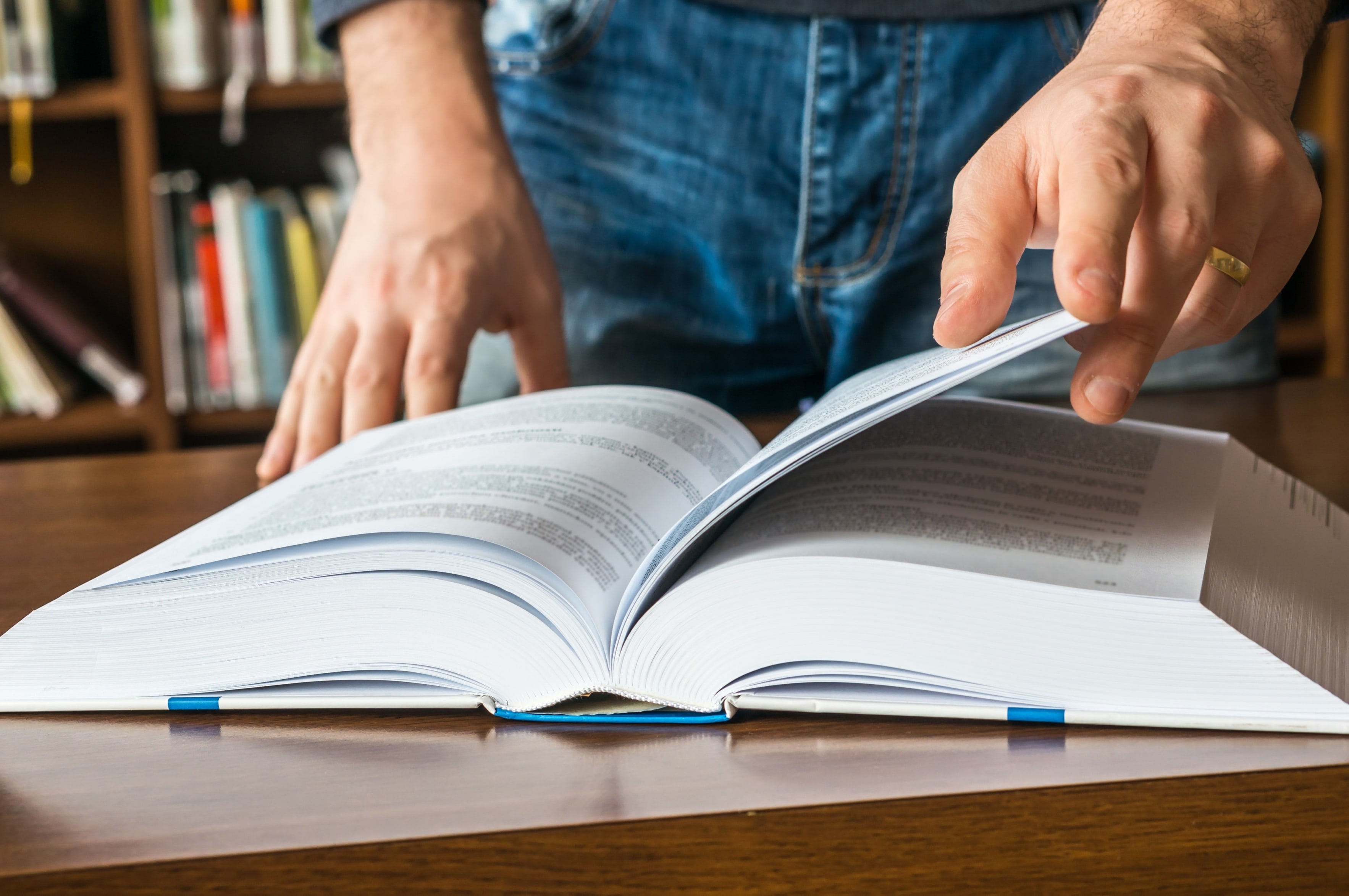 Primer plano de las manos de una persona hojeando un libro