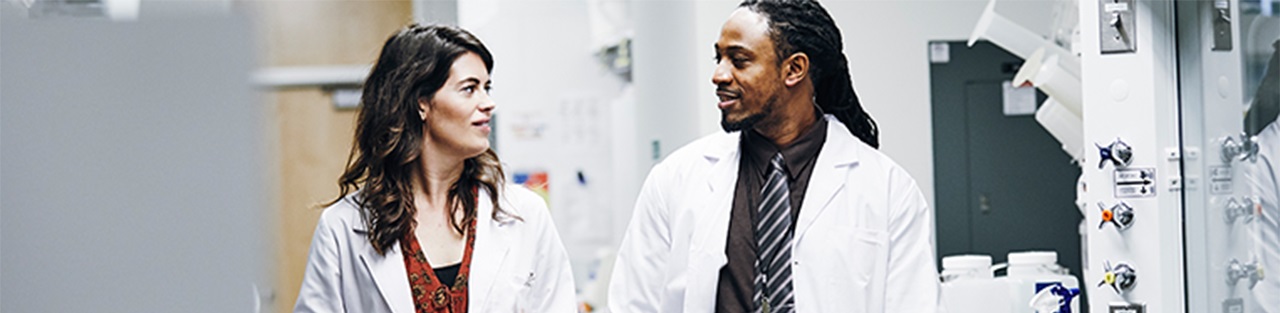 Two professionals looking at each other in a lab