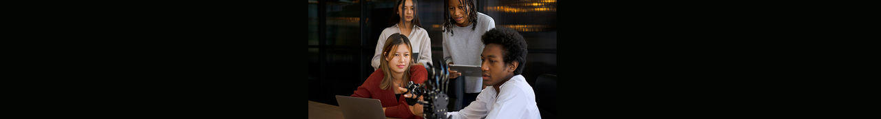 Four students working with robot arm project